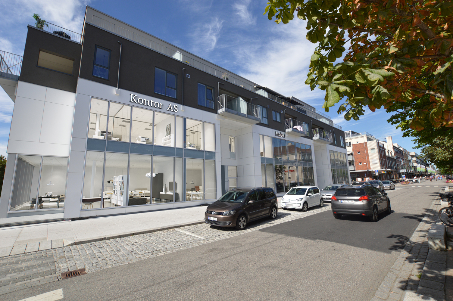 en gjengivelse av en bygning med biler parkert foran den.