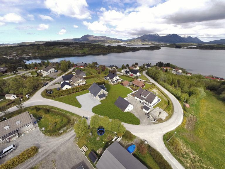 Luftfoto av et hus med en innsjø i bakgrunnen for å visualisere salgsformål i 2016.