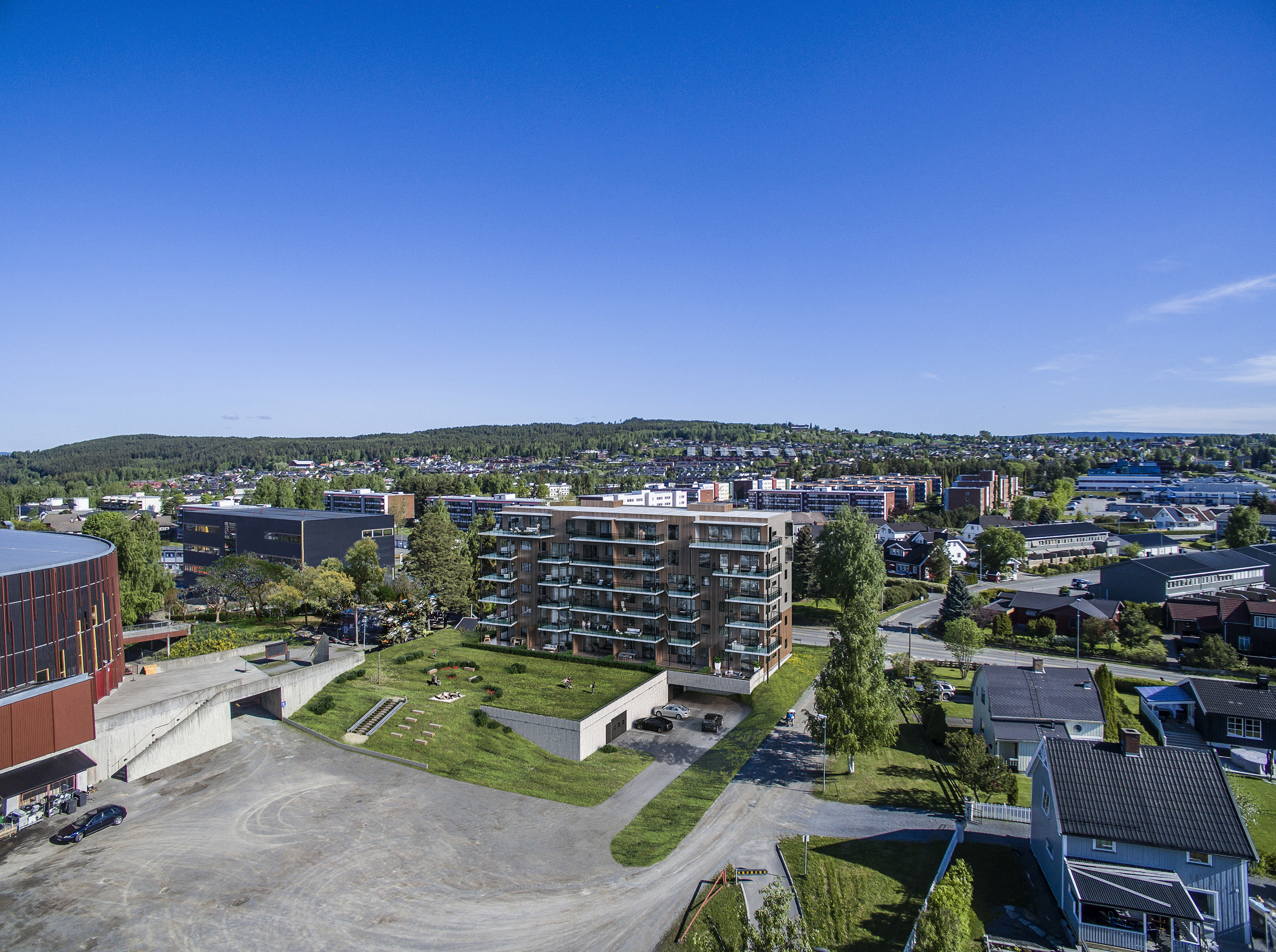 Visualisering for salg: luftfoto av en bygning og en parkeringsplass.