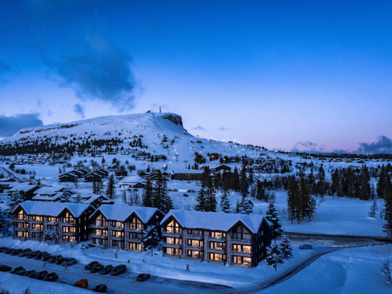 et hotell i snøen med et fjell i bakgrunnen.