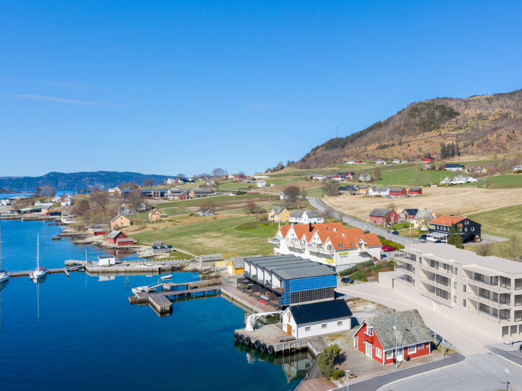 et luftfoto av en havn i en liten by i norge.