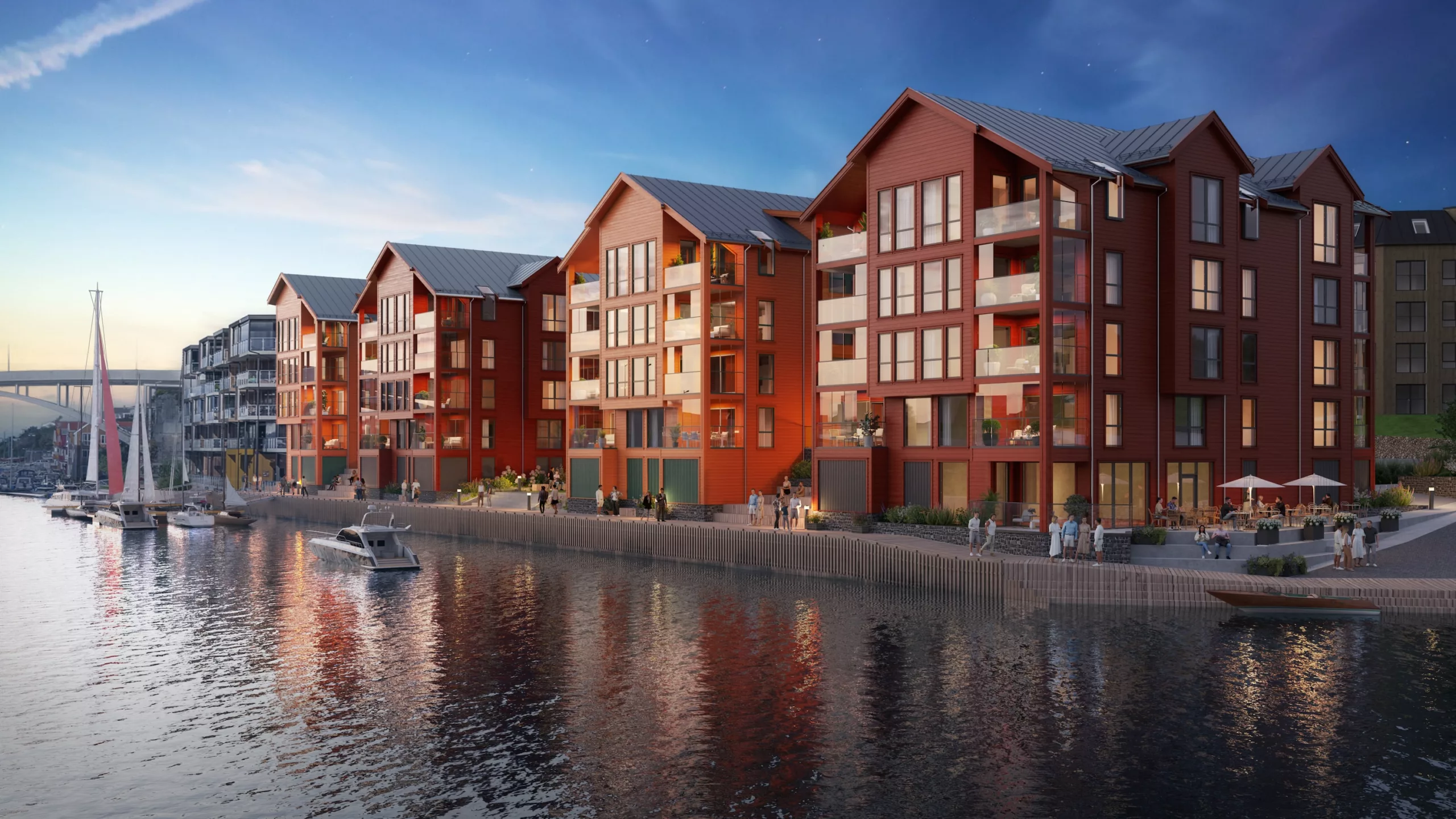En rekke moderne røde bygninger med store vinduer langs en vannkant, med en båt som ligger til kai i nærheten og folk som går langs promenaden under en skumringshimmel.