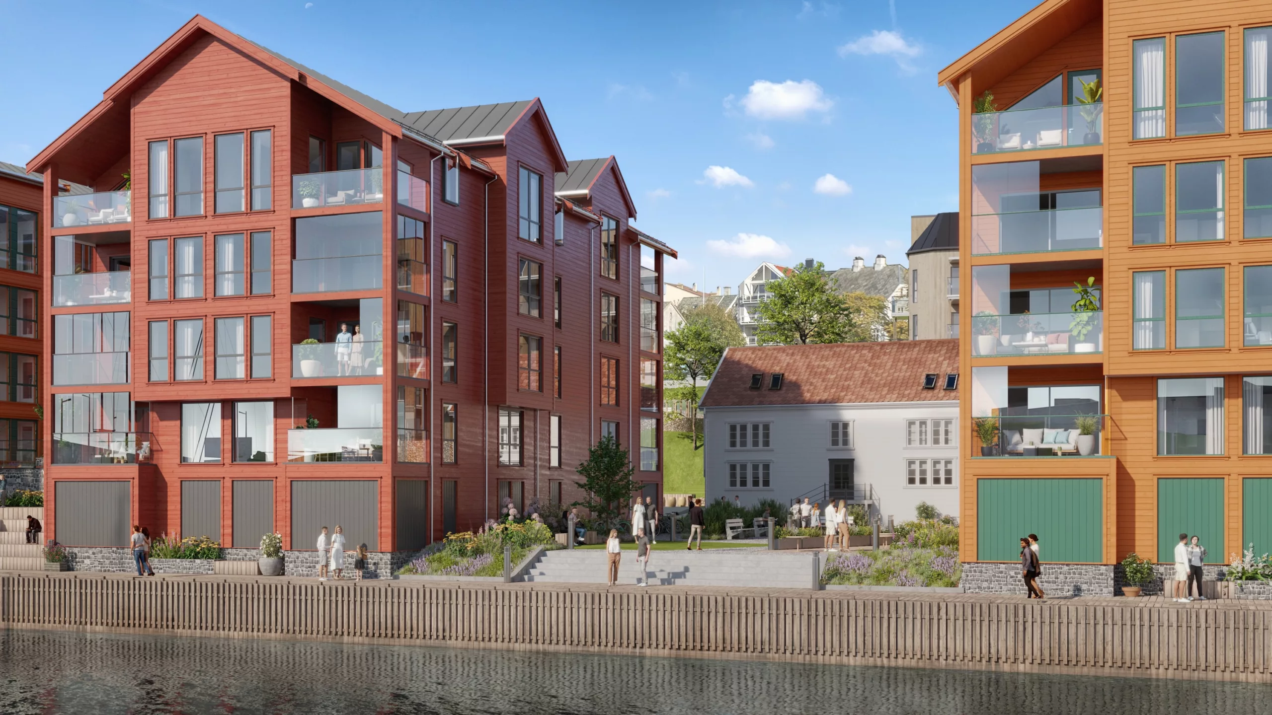 Moderne leilighetsbygg ved sjøen med store vinduer og balkonger, omgitt av anlagt grøntområder og en trebrygge, under en klarblå himmel.