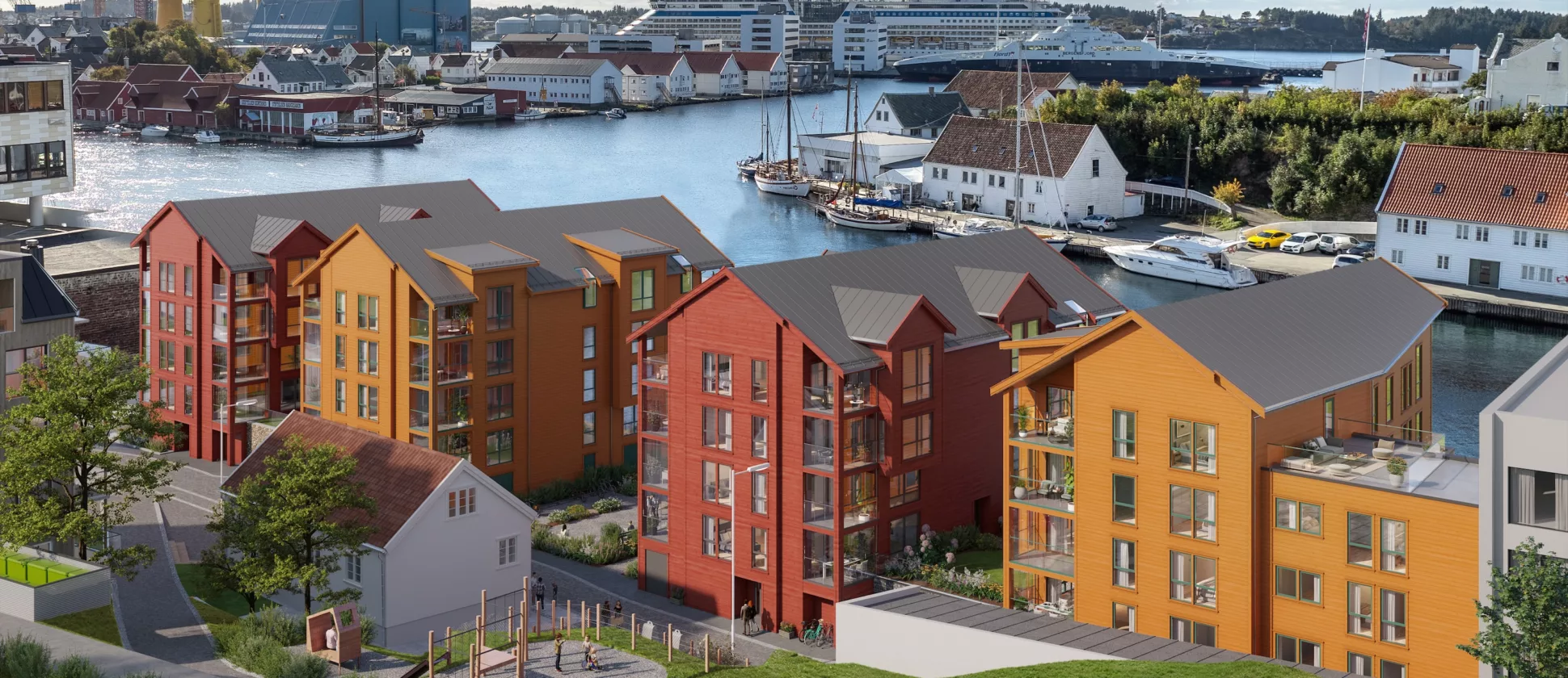 Fargerike bygårder nær en vannkant med skip og et verft i bakgrunnen under en delvis overskyet himmel.