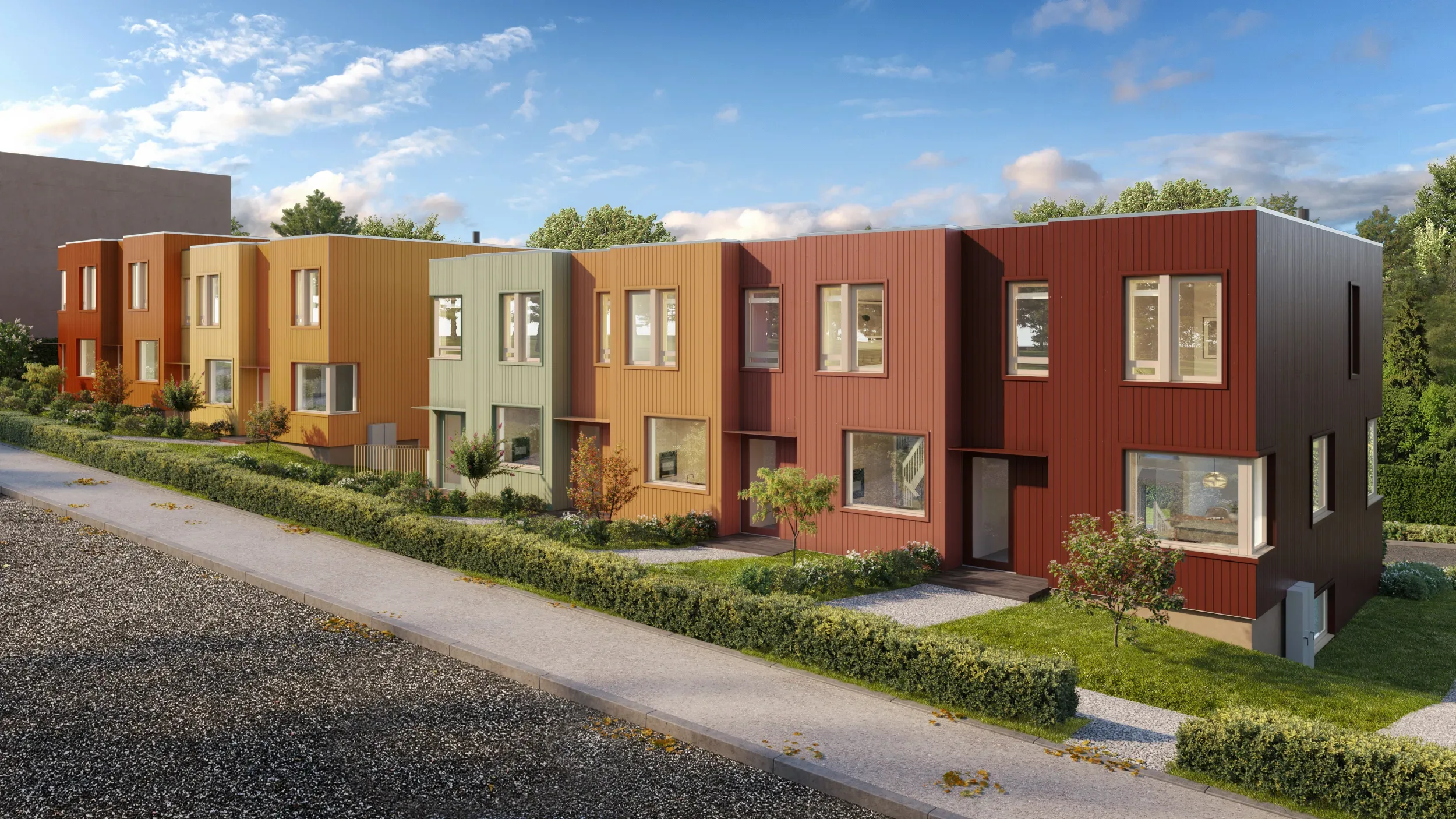 En rekke moderne, fargerike rekkehus med små forhager, grønne planter og en klarblå himmel i bakgrunnen.